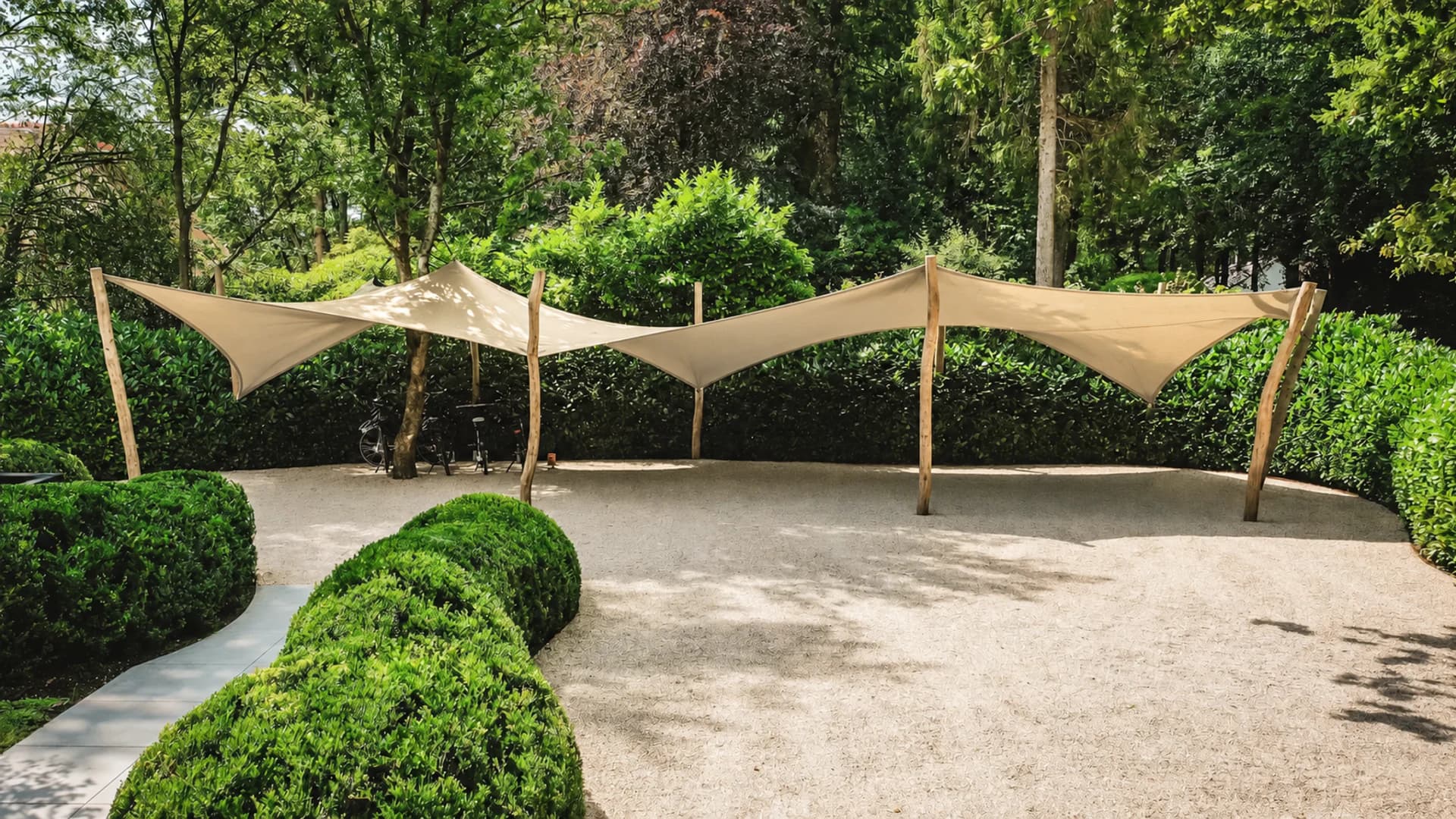 Beige carports van stretchdoek op maat in een groene omgeving