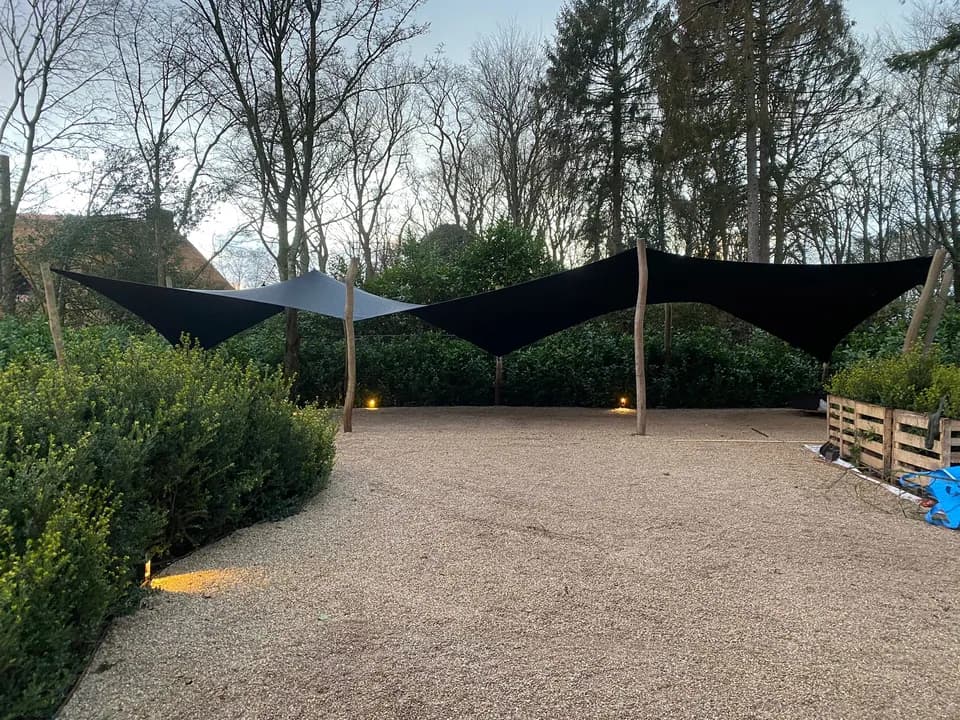 Dubbele stretchtent-carport op een groene buitenlocatie