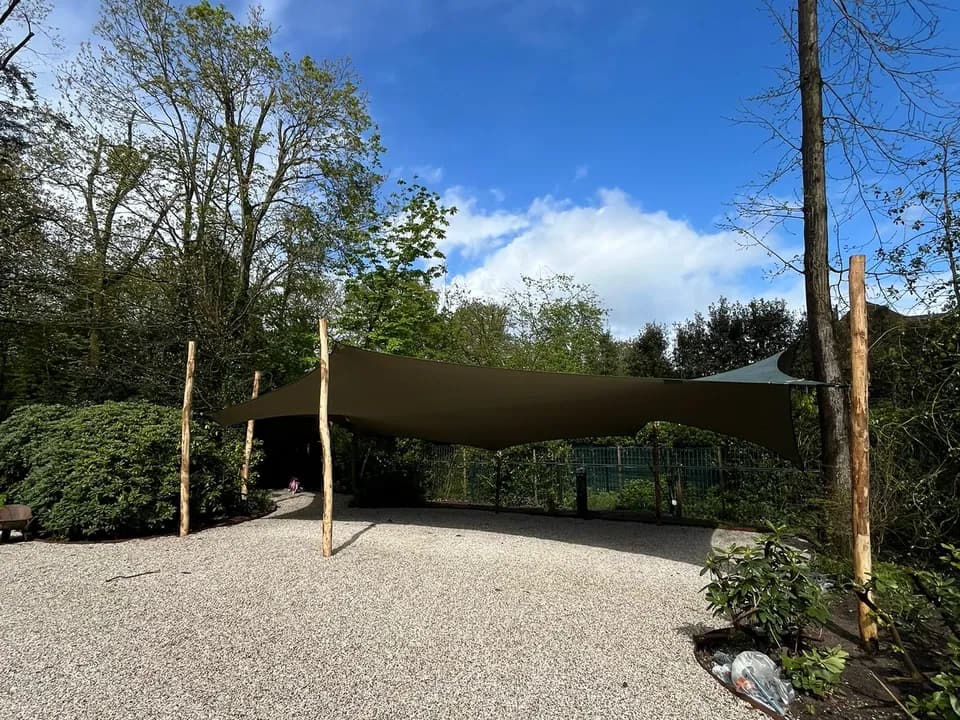 Bruine stretchtent-carport op een bosrijke oprit