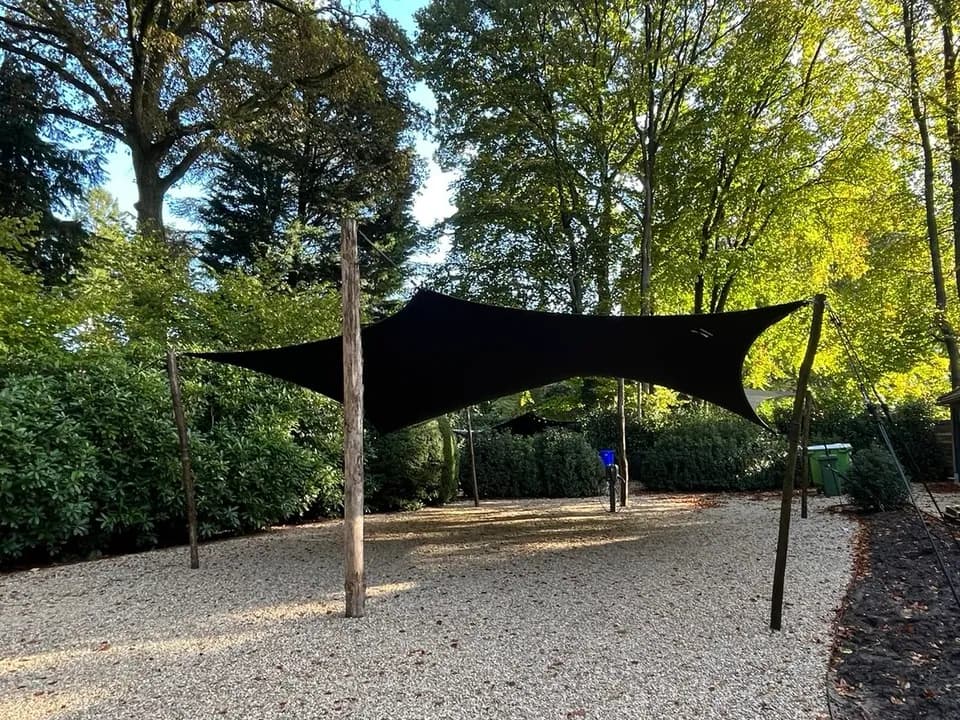 Zwarte maatwerk carport rond bestaande bomen