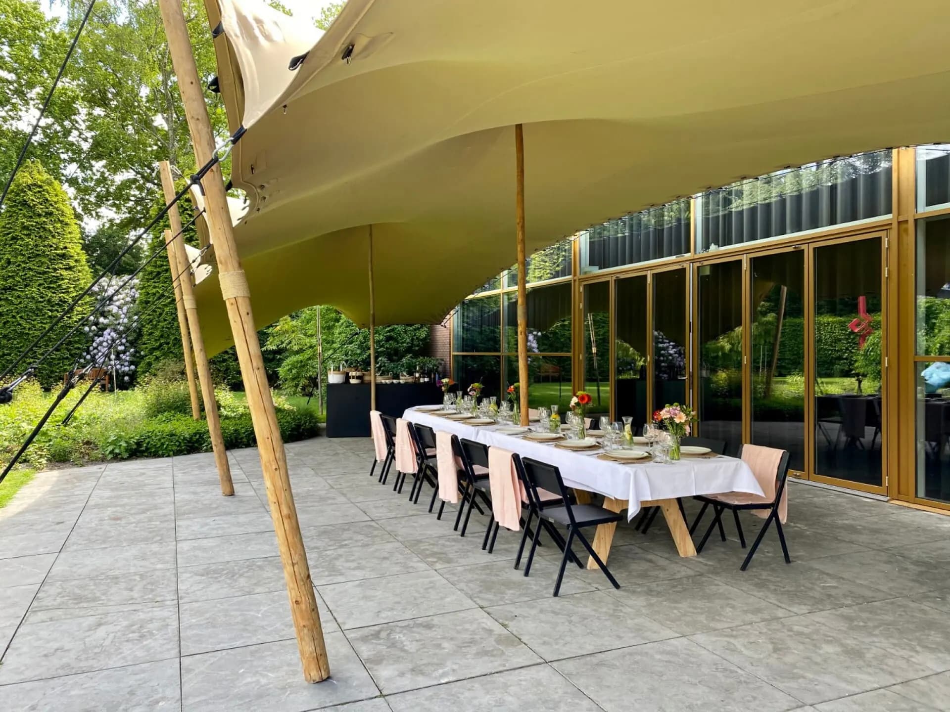 Bestaand terras onder een custom-fit stretchtent bij Singer Laren als voorbeeld van maatwerk